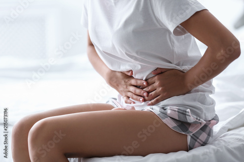 Young woman suffering from menstrual cramps at home. Gynecology photo