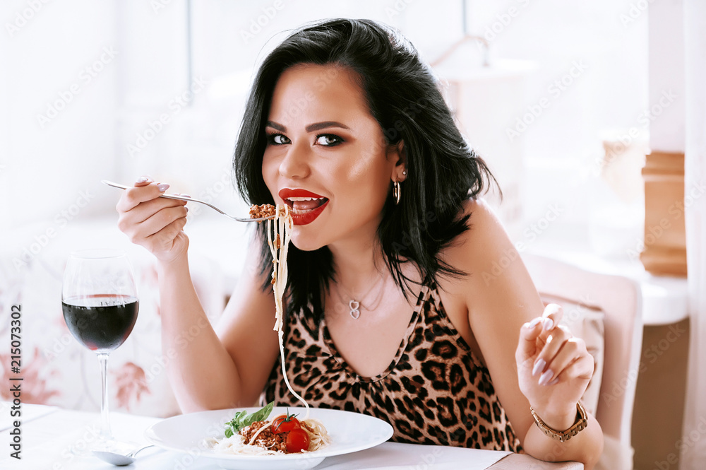 girl eating pasta in a restaurant washing down her red wine girl eating pasta in a restaurant washing down her red wine