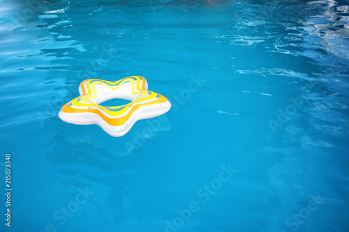 Inflatable ring floating in swimming pool on sunny day © New Africa