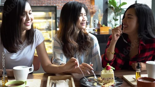 Friends group of three Asian female  enjoying a strawberry cake and having a conversation at cafe and restaurant photo