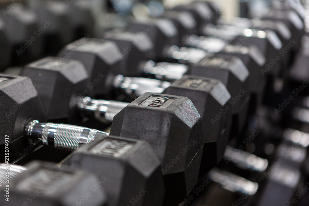 Obraz premium A row of dumbbells racked with a selective focus