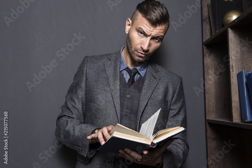 фотографія Portrait of stylish, elegant young man in suit with book