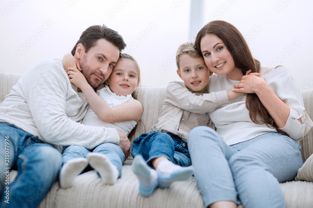 parents hug their children sitting on the couch parents hug their children sitting on the couch