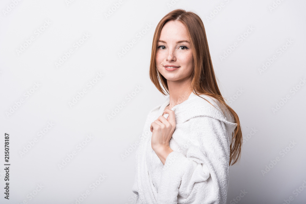 Beautiful red-haired girl in a white bathrobe on a light background Beautiful red-haired girl in a white bathrobe on a light background