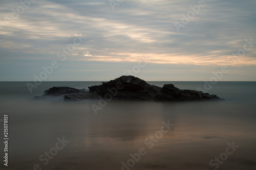 Long exposure of a rock in the sea at sunset 