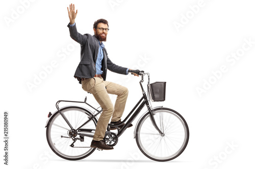 Bearded man riding a bicycle and waving at the camera