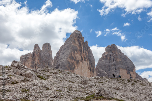 View towards the tops of the Tre Cime di Lavaredo with two mountaineers underneath, Dolomites, Italy