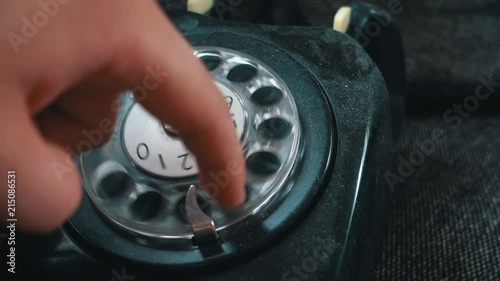 Calling on an old vintage rotation phone and dialing a number photo
