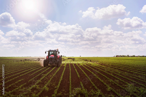 Foto Tractor on soy field spraying
