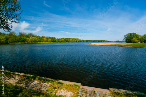 Water reservoir under blue sky on sunny day. Sunny countryside landscape