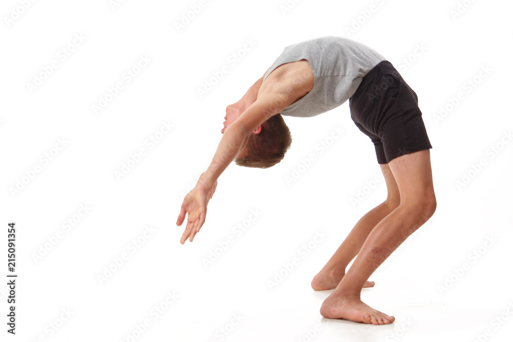 Teen in a T-shirt and shorts performs gymnastic exercises. Teen in a T-shirt and shorts performs gymnastic exercises.