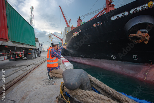 Stevedore forman, supervisor, harbour master, port captain working in charge of command in loading discharging containers shipment operation,  at port terminal photo