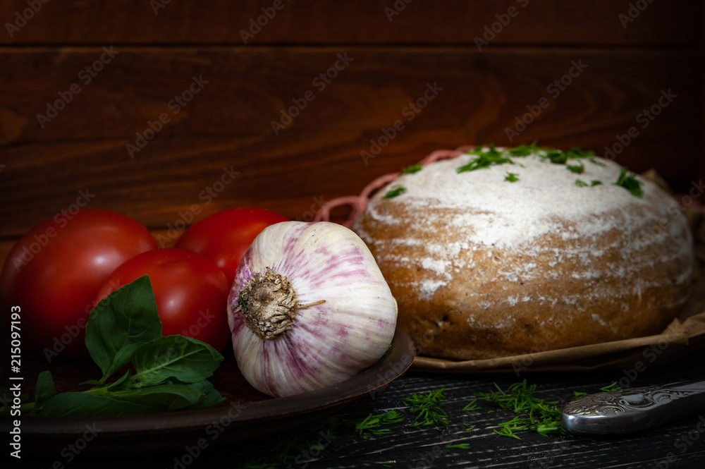 fresh baked bread with tomatoes and garlic with basil on a dark wooden background fresh baked bread with tomatoes and garlic with basil on a dark wooden background