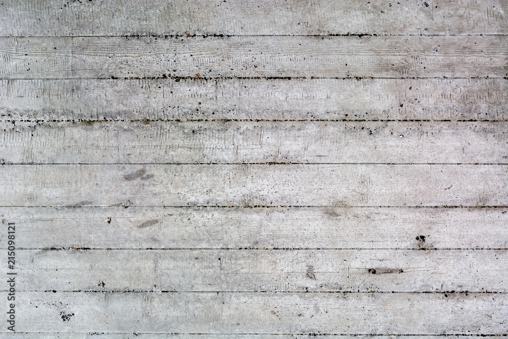 Naklejka premium An old surface of concrete with impressions of rough boards. Gray industrial background. Copy space.