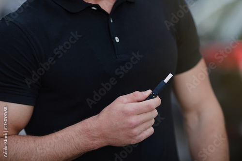 Close-up of a man with electronic cigarette. Tobacco system IQOS