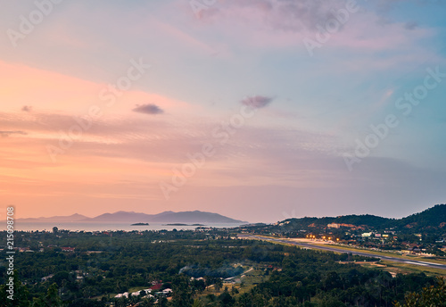 Colourful sunset over airport  mountains and forest on a tropical island      