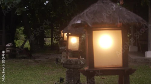 Lanterns Aligned In Garden Surrounded By Trees - Static  photo