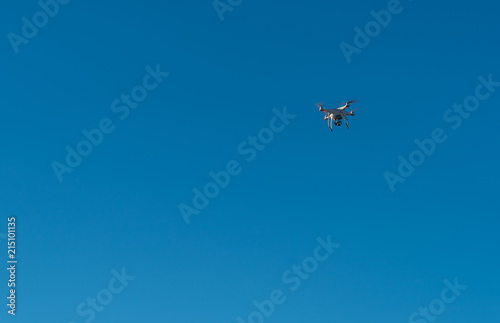 Fototapeta Naklejka Na Ścianę i Meble -  Modern Drone with camera flying on blue sky background.