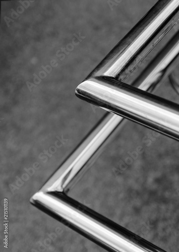 Polished stainless pipes welded at an angle. Gray industrial background. Diagonal. photo