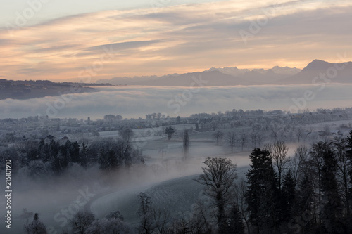 Ice cold winter morning with fog and Mount Rigi in the background during the dawn in Central Switzerland