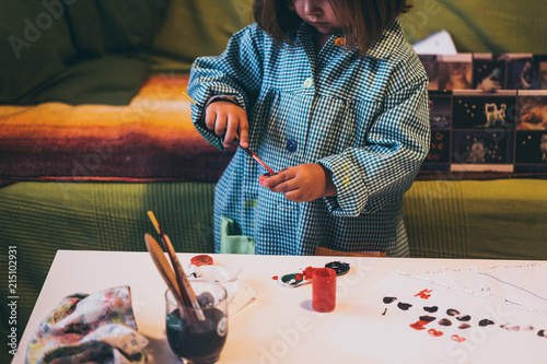 Una niña juega con pinturas y temperas