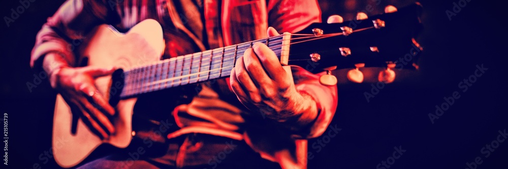 Fototapeta premium Mid-section of man playing guitar 