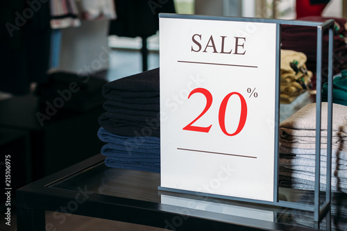 Sign in a clothing store with discount inscription SALE 20 % percent. Plate discount (sale)