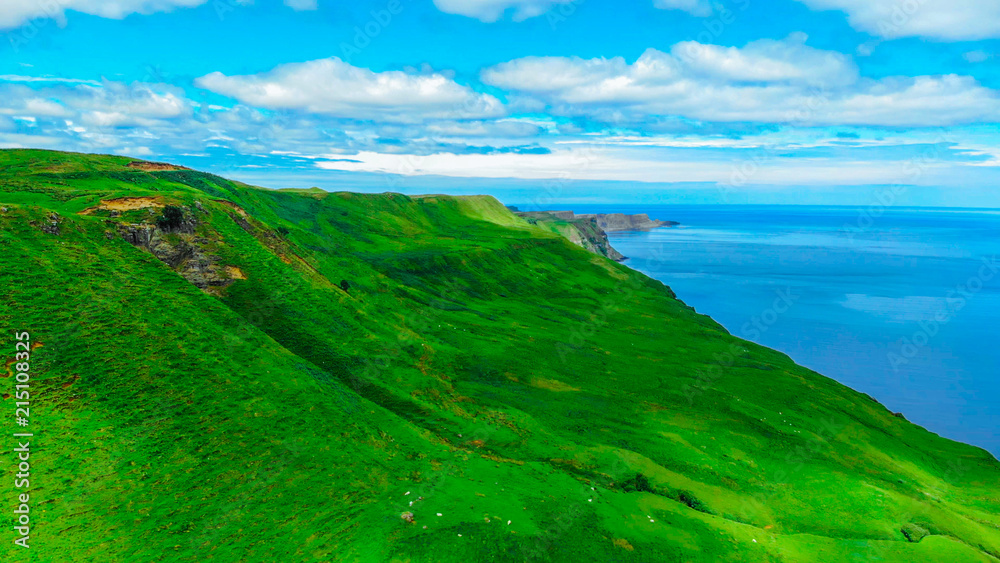 Aerial view over the green coastline and cliffs on the Isle of Skye in Scotland