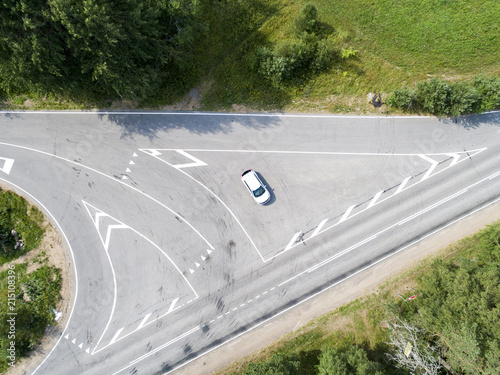 Aerial view of highway. Aerial view of a country road with moving car. Car passing by. Aerial road. Aerial view flying. Captured from above with a drone.