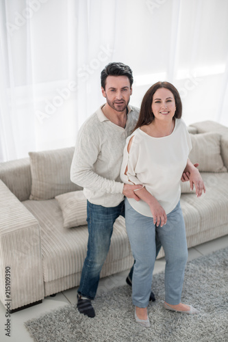 happy couple standing spacious living room. © ASDF