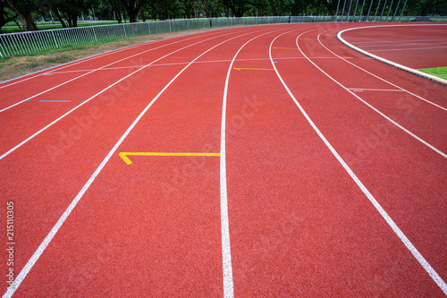 White lines of stadium and texture of running racetrack red rubber racetracks in outdoor stadium are 8 track and green grass field,empty athletics stadium with track.