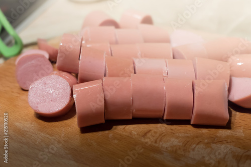 Sliced sausage rings on the wooden table photo