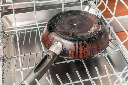 Dirty frying pan lies in the dishwasher