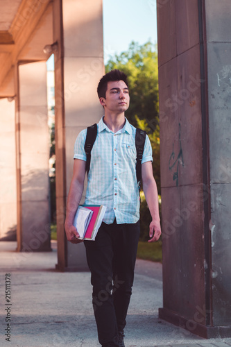Student with the books walking at the front of university