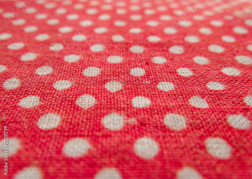 Close-up of red cotton cloth in white peas with perspective distortions.