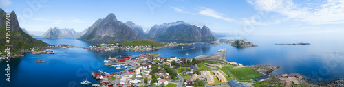 Beautiful aerial panorama of  the blue sea surrounding the fishing village  and rocky peaks Reine, Moskenes, Lofoten, Norway, sunny arctic summer  © raland