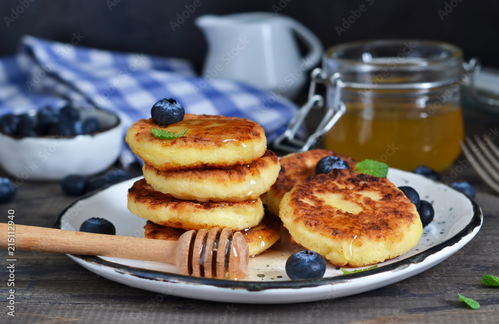 Classic Russian breakfast - cheesecake with honey and berries.