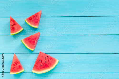 Top view of watermelon slices on a turquoise wooden background