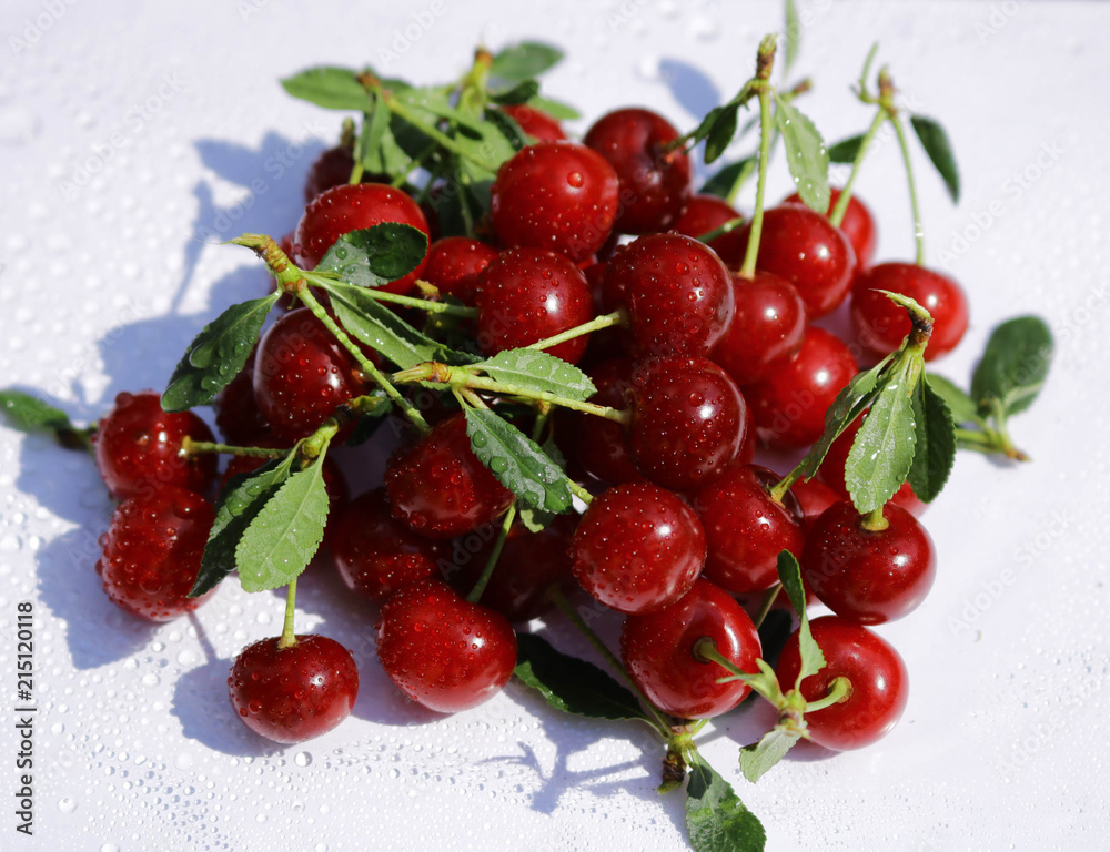 A bunch of cherry berries ripe red with leaves close-up. Cherry is a natural garden. A bunch of cherry berries ripe red with leaves close-up. Cherry is a natural garden.