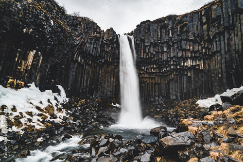 Dramatic morning view of famous Svartifoss  Black Fall  Waterfall. Colorful summer sunrise in Skaftafell  Vatnajokull National Park  Iceland  Europe. Artistic style post processed photo.
