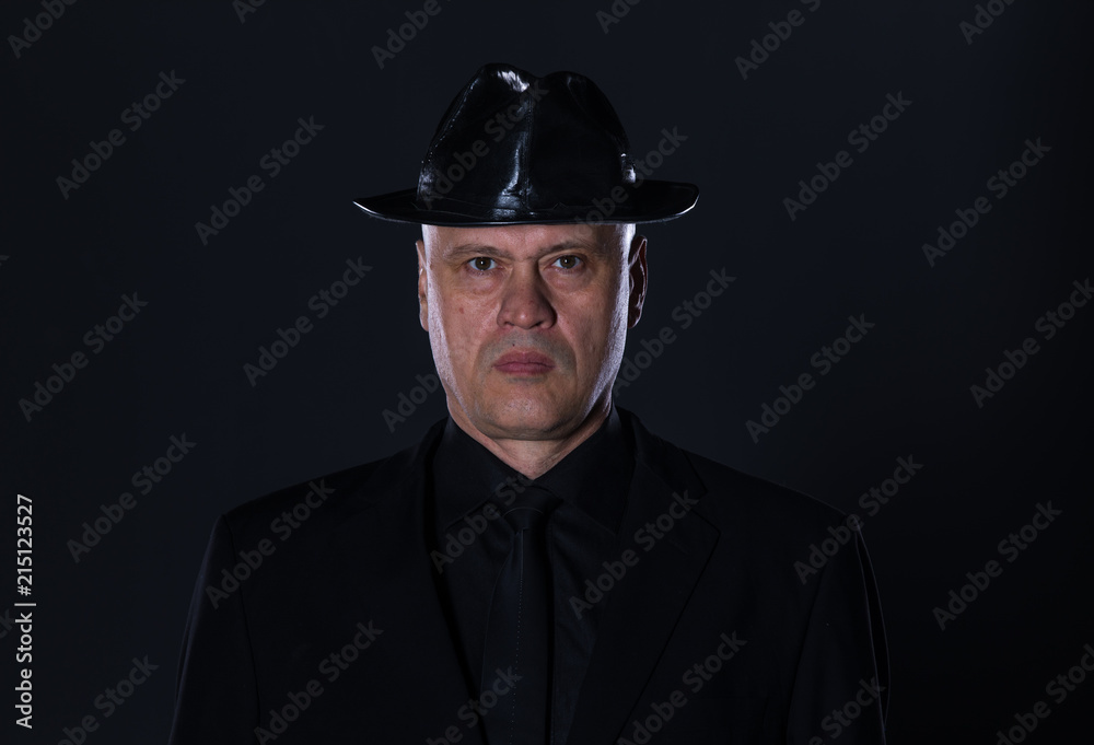 studio portrait of a 50 year old man in black clothes on a black background