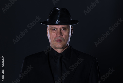 studio portrait of a 50 year old man in black clothes on a black background