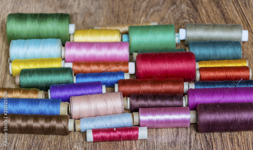Multi Colored Thread Yarns on Wooden Background Multi Colored Thread Yarns on Wooden Background