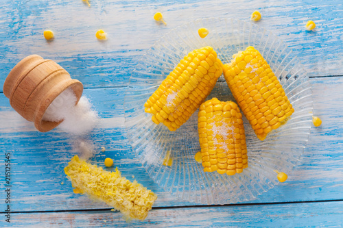 eaten corn cob on the background of whole lying on a wooden blue-white table with top view photo