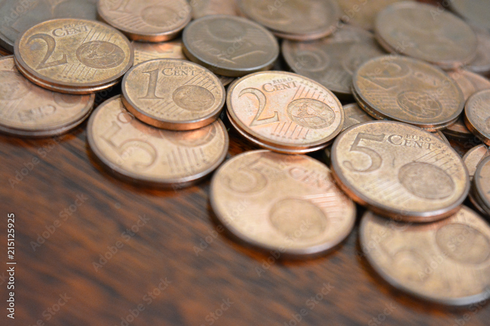 Euro cent coins. 1 euro, 2 euro and 5 euro cent coins on wood table. Euro cent coins. 1 euro, 2 euro and 5 euro cent coins on wood table.