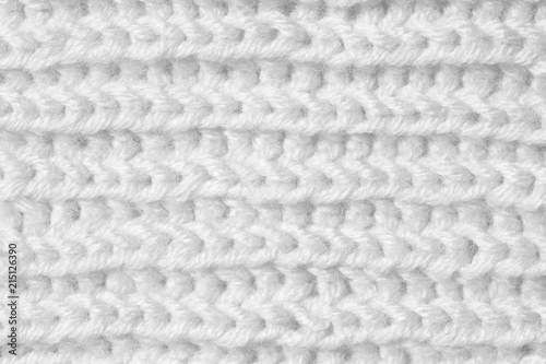 Knitting from woolen threads handmade. The texture is white, the background of the canvas is connected from the thread.