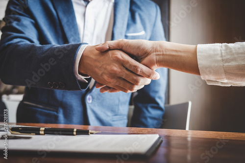 Real estate agent and customers shaking hands together celebrating finished contract after about home insurance and investment loan, handshake and successful deal photo