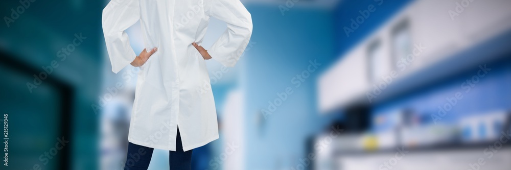 Composite image of doctor standing with hands on hip against