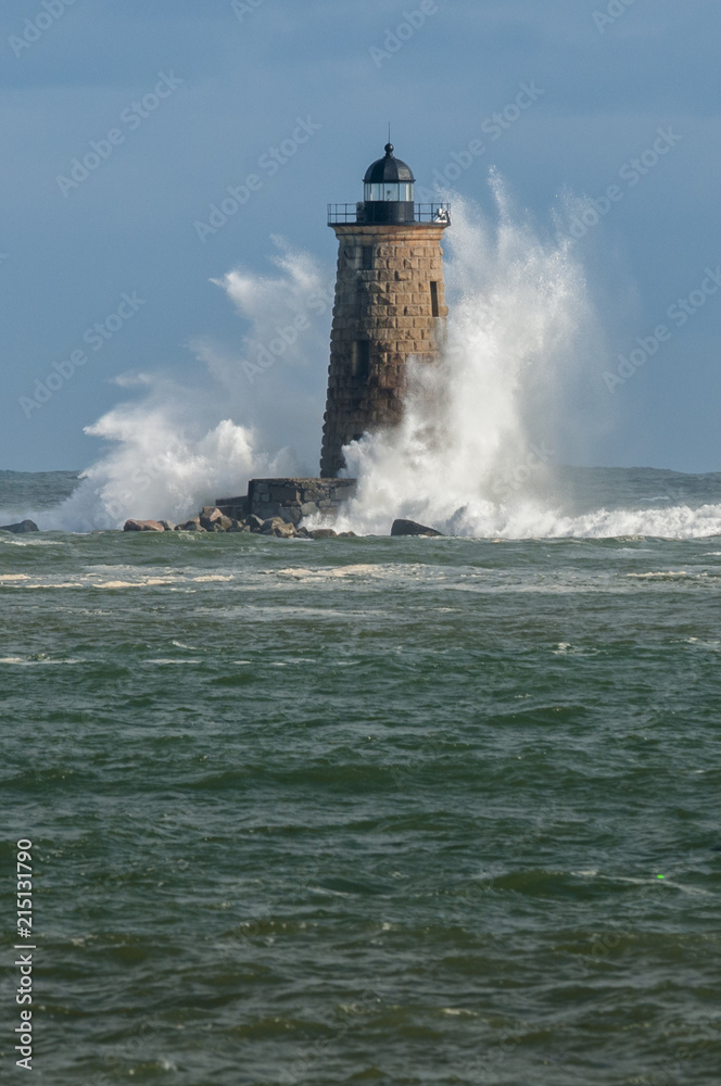 Sunlit Stone Lighthouse Tower Covered by Huge Waves From Rare High Tide