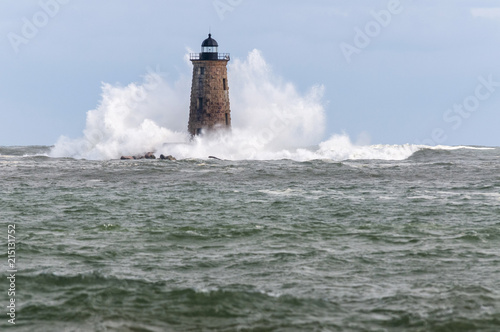 Huge Waves Break Around Stone Tower of Whaleback Lighthouse in Maine photo